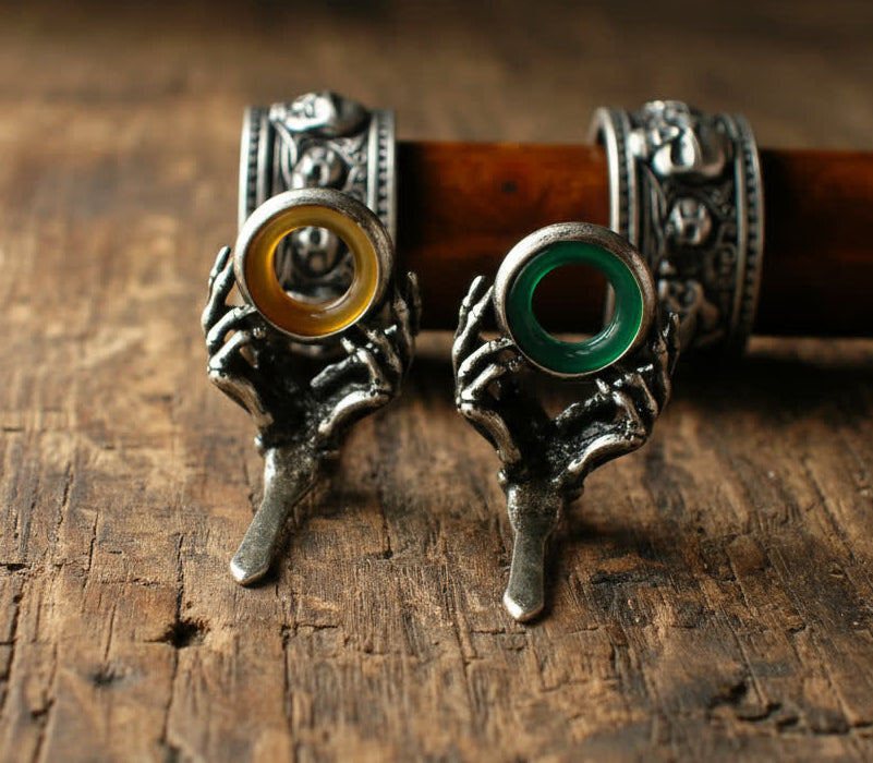 Pair of silver guides with colored stones on a wooden surface