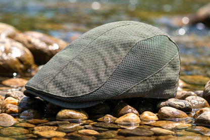 Green cap on a bed of rocks with water in the background