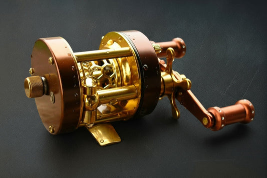 Gold and bronze fishing reel on a dark background