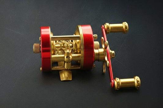 Gold and red fishing reel on a black background