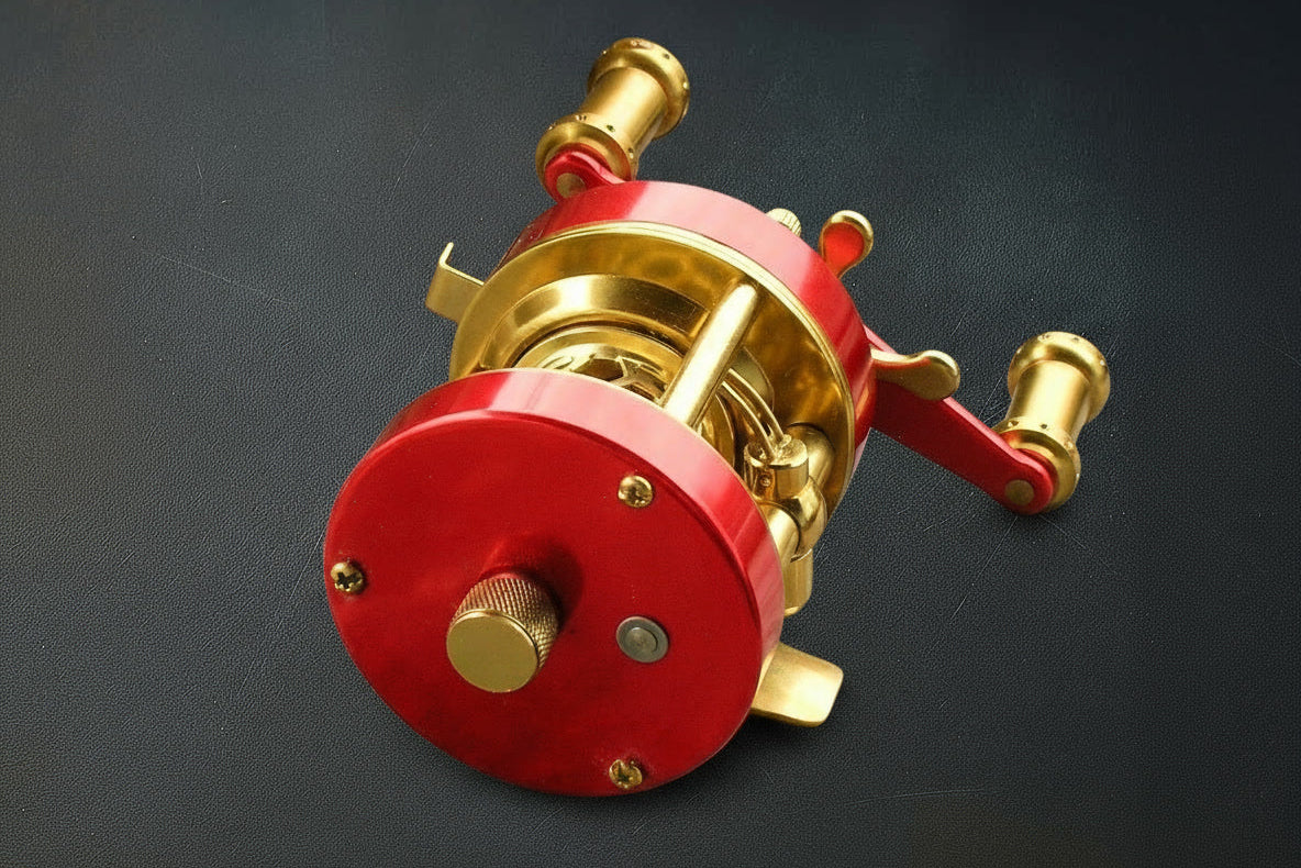 Red and gold fishing reel on a dark background