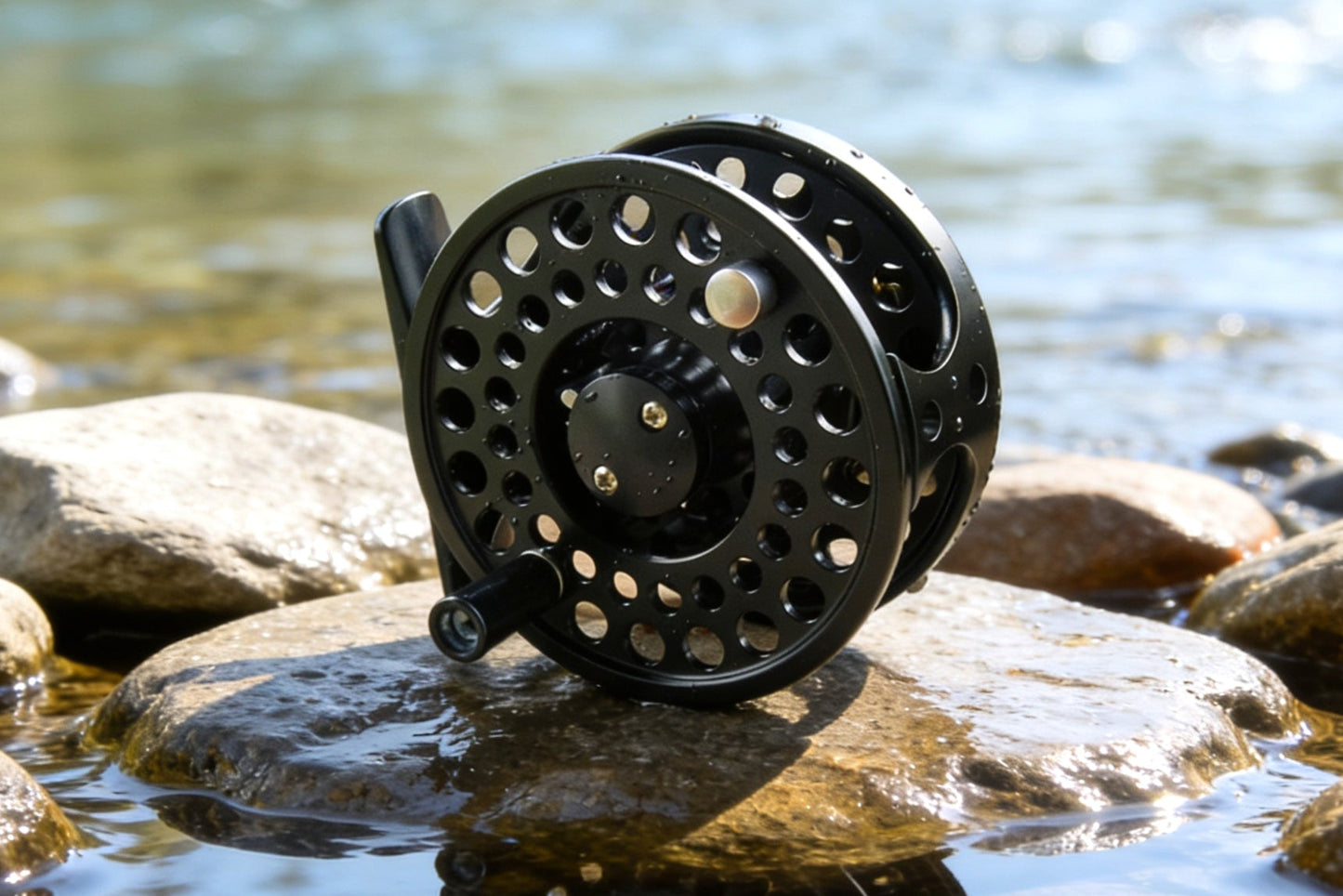 Black fly fishing reel on a rock by a water body