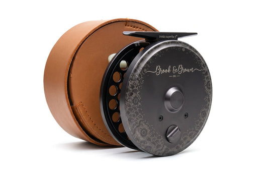 Fishing reel with brown leather casing on a white background