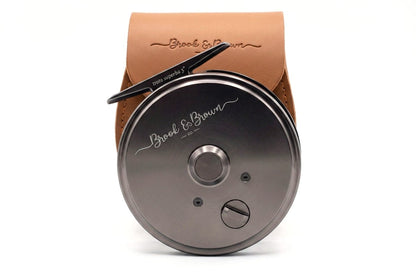 Fishing reel with leather case on a white background
